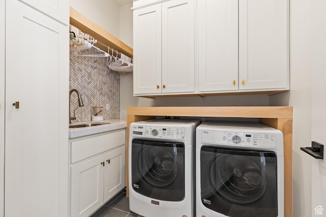 washroom featuring tile patterned floors, washing machine and clothes dryer, a sink, and cabinet space