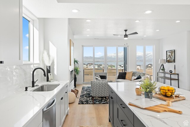 113 E Watson Dr S, Saratoga Springs, UT 84045 - kitchen with light stone counters, stainless steel dishwasher, sink, and backsplash