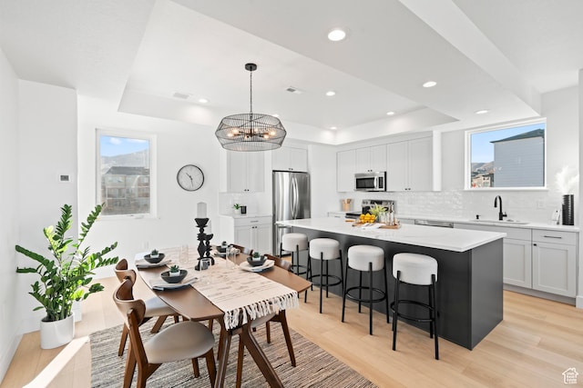 113 E Watson Dr S, Saratoga Springs, UT 84045 - kitchen featuring sink, appliances with stainless steel finishes, a raised ceiling, a kitchen island, and pendant lighting