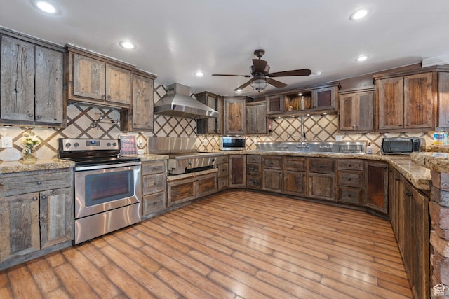 75 N 200 W, Kanab, UT 84741 - kitchen featuring wall chimney range hood, light hardwood / wood-style flooring, stainless steel appliances, dark brown cabinetry, and light stone countertops