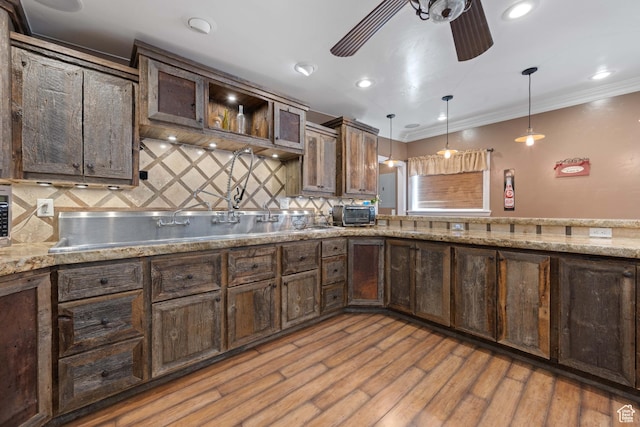 75 N 200 W, Kanab, UT 84741 - kitchen with dark brown cabinetry, crown molding, light hardwood / wood-style flooring, pendant lighting, and ceiling fan