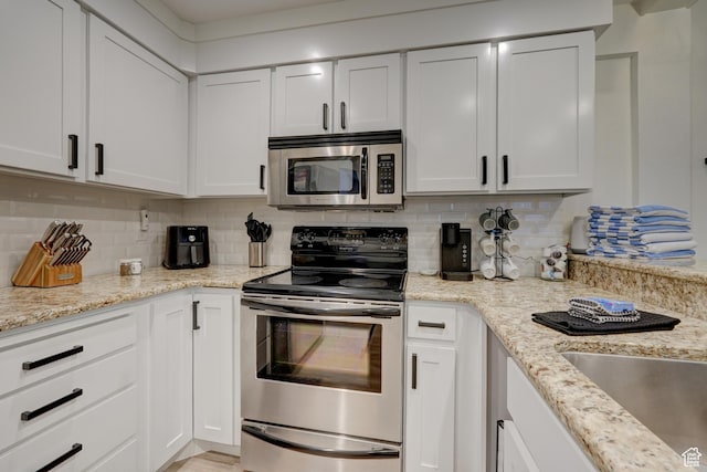 407 S Vasels Rd Unit 8, Brian Head, UT 84719 - kitchen with stainless steel appliances, white cabinetry, tasteful backsplash, and light stone counters