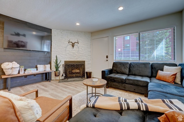407 S Vasels Rd Unit 8, Brian Head, UT 84719 - living room with a fireplace, a textured ceiling, and light wood-type flooring