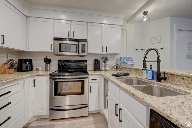 407 S Vasels Rd Unit 8, Brian Head, UT 84719 - kitchen featuring appliances with stainless steel finishes, white cabinetry, sink, backsplash, and light stone countertops