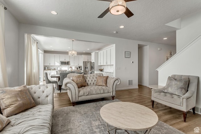 739 W Wild Hyacinth Dr, Saratoga Springs, UT 84045 - living room with ceiling fan with notable chandelier, light hardwood / wood-style flooring, and a textured ceiling