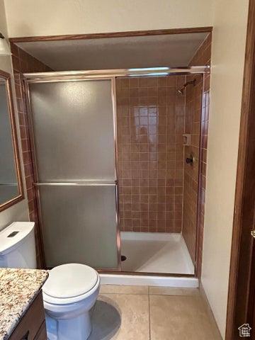 150 W Ridge View St Unit 241, Brian Head, UT 84719 - bathroom featuring a shower with door, vanity, tile patterned flooring, and toilet