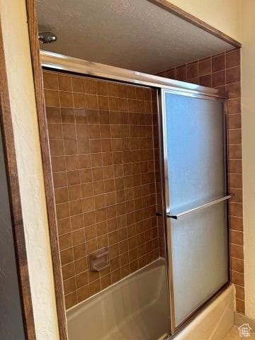 150 W Ridge View St Unit 241, Brian Head, UT 84719 - bathroom with combined bath / shower with glass door and a textured ceiling