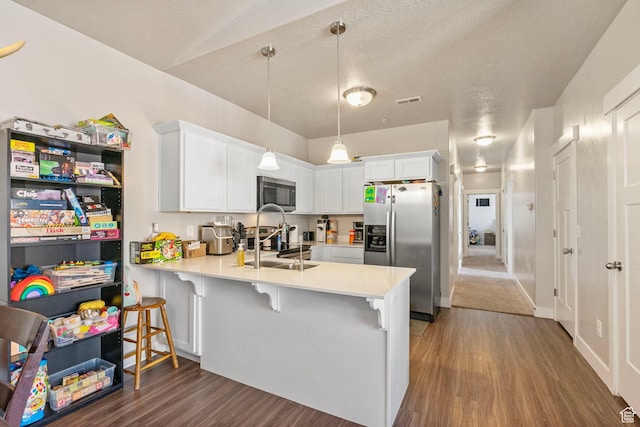 1772 W Tera Vista Ln Unit G302, Saratoga Springs, UT 84045 - kitchen with appliances with stainless steel finishes, decorative light fixtures, white cabinetry, a kitchen bar, and kitchen peninsula