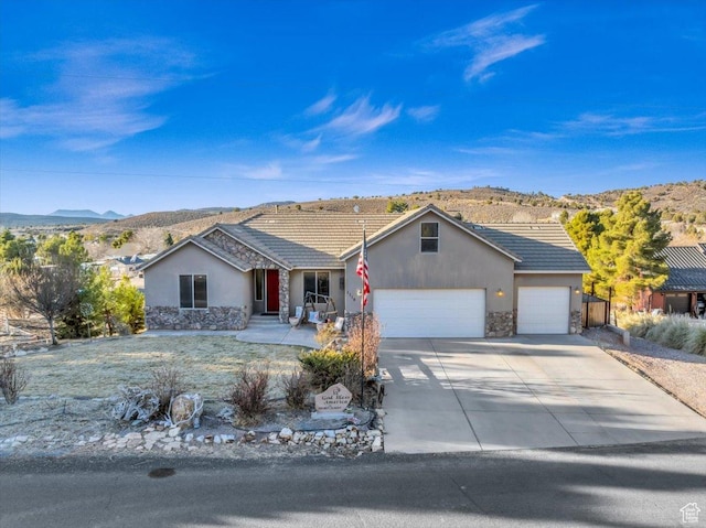 ranch-style home featuring a garage and a mountain view