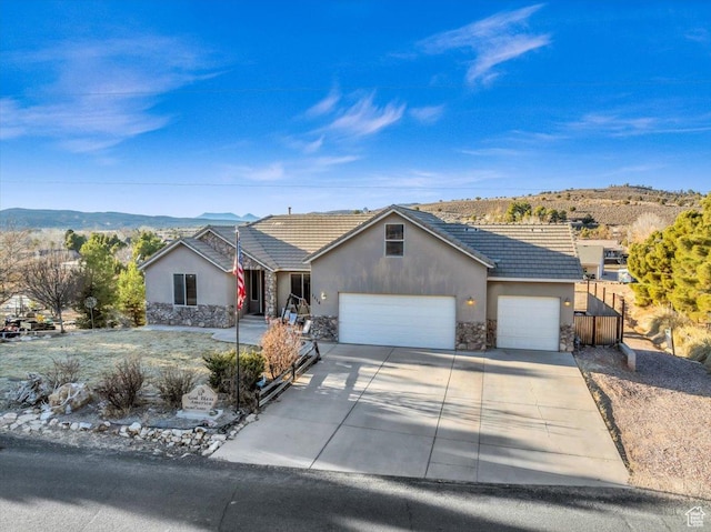 ranch-style house featuring a garage and a mountain view