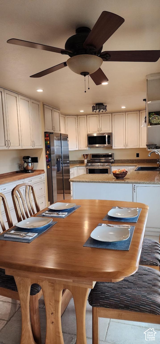 dining space with sink and ceiling fan