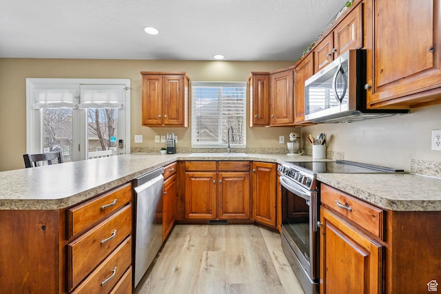 700 S Clearwater Falls Dr E, Layton, UT 84041 - kitchen with appliances with stainless steel finishes, sink, light hardwood / wood-style flooring, and kitchen peninsula