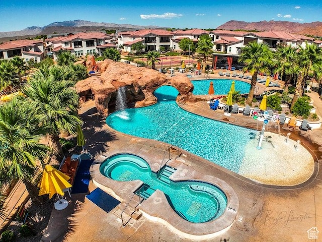 3780 Arcadia Dr Unit 51, Santa Clara, UT 84765 - view of swimming pool featuring pool water feature, a hot tub, a mountain view, and a patio area