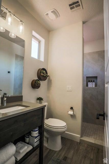 3780 Arcadia Dr Unit 51, Santa Clara, UT 84765 - bathroom with hardwood / wood-style flooring, vanity, a tile shower, and toilet