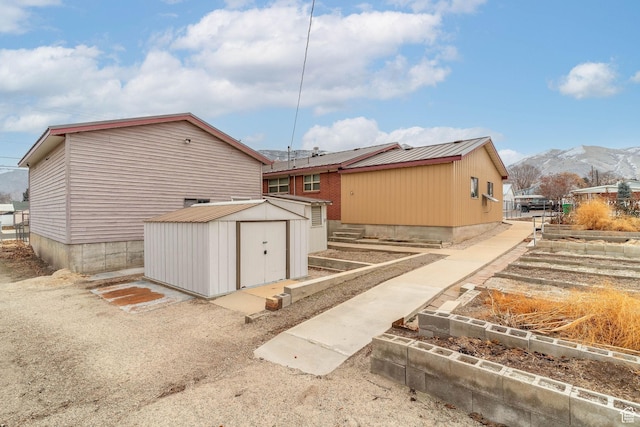 view of property exterior featuring a mountain view and a storage shed