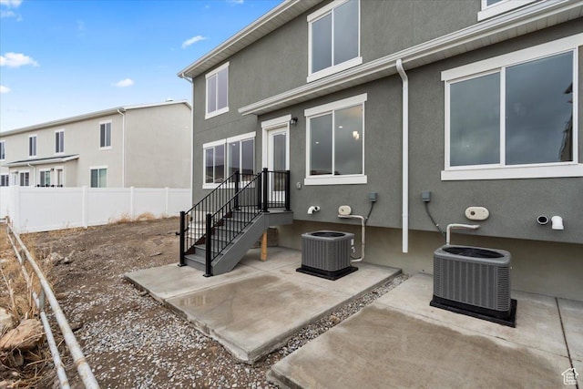 back of property featuring a patio area, stucco siding, cooling unit, and fence