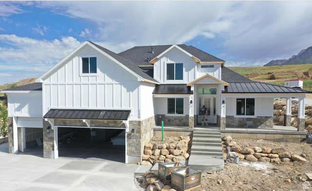 modern farmhouse with a mountain view, a garage, and covered porch