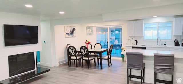 1600 W 4300 S, Salt Lake City, UT 84123 - kitchen with a sink, a kitchen breakfast bar, light countertops, light wood-type flooring, and recessed lighting