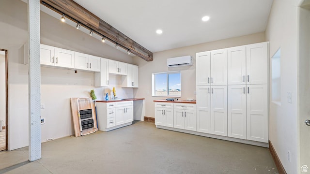 6668 S 3200 W, Spanish Fork, UT 84660 - kitchen with white cabinets, a sink, beam ceiling, a wall unit AC, and finished concrete floors