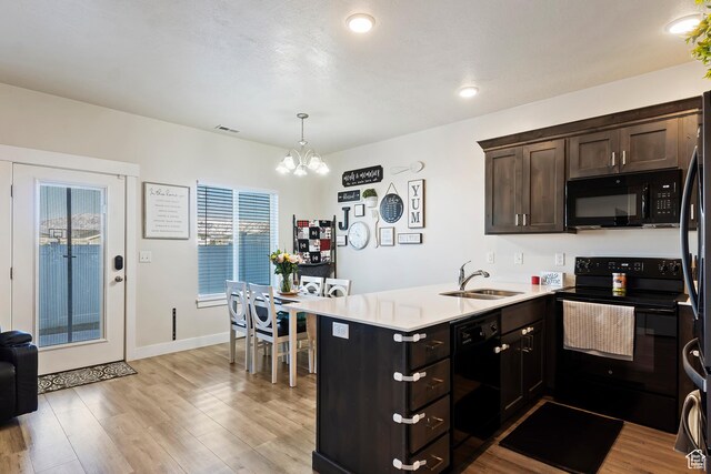 2390 W Jade Way Unit 2, West Haven, UT 84401 - kitchen featuring dark brown cabinetry, a peninsula, a sink, light wood-style floors, and black appliances