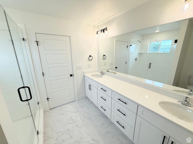 bathroom featuring marble finish floor, double vanity, a sink, and a shower stall