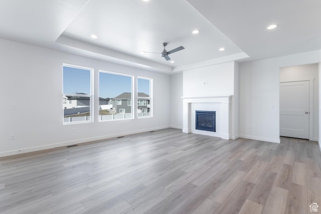 3047 N 2875 W Unit 7, Plain City, UT 84404 - unfurnished living room with a raised ceiling, a ceiling fan, recessed lighting, light wood-type flooring, and a glass covered fireplace