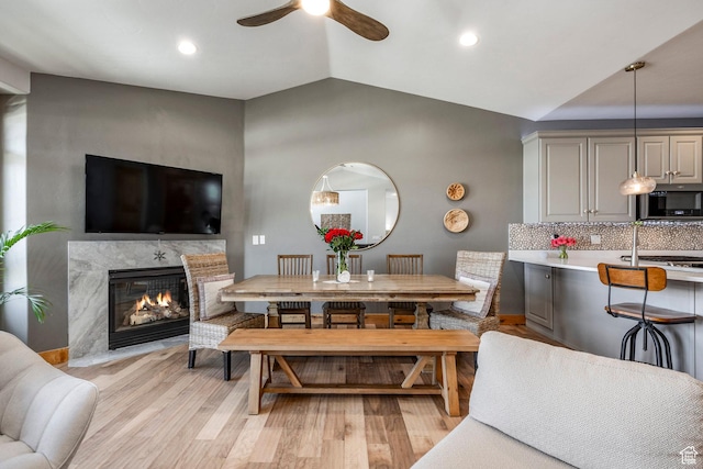 14084 N Council Fire Trl Unit 14D, Kamas, UT 84036 - dining space featuring vaulted ceiling, ceiling fan, a fireplace, and light wood-type flooring