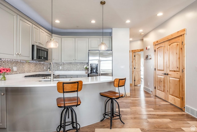 14084 N Council Fire Trl Unit 14D, Kamas, UT 84036 - kitchen featuring stainless steel appliances, light hardwood / wood-style floors, a kitchen breakfast bar, and decorative light fixtures