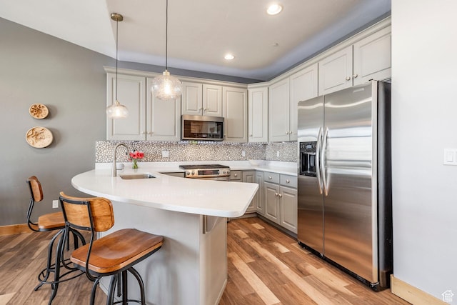 14084 N Council Fire Trl Unit 14D, Kamas, UT 84036 - kitchen featuring decorative light fixtures, sink, a kitchen breakfast bar, kitchen peninsula, and stainless steel appliances