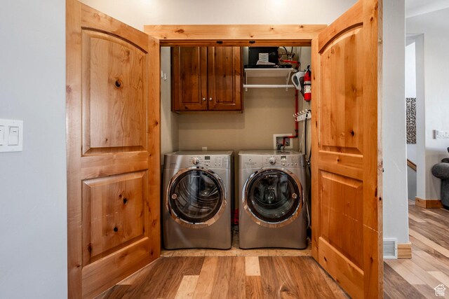 14084 N Council Fire Trl Unit 14D, Kamas, UT 84036 - clothes washing area with cabinets, washing machine and dryer, and light hardwood / wood-style flooring