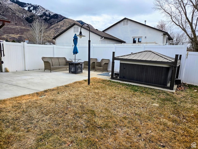 view of yard with an outdoor fire pit, a mountain view, and a patio area