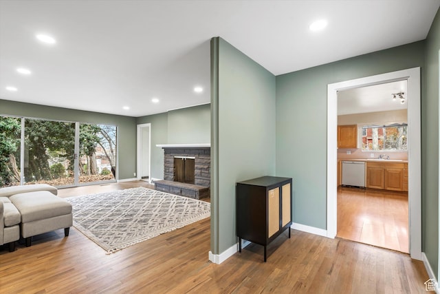 1320 Country Hills Dr, Ogden, UT 84403 - living room featuring sink, a stone fireplace, and light hardwood / wood-style floors