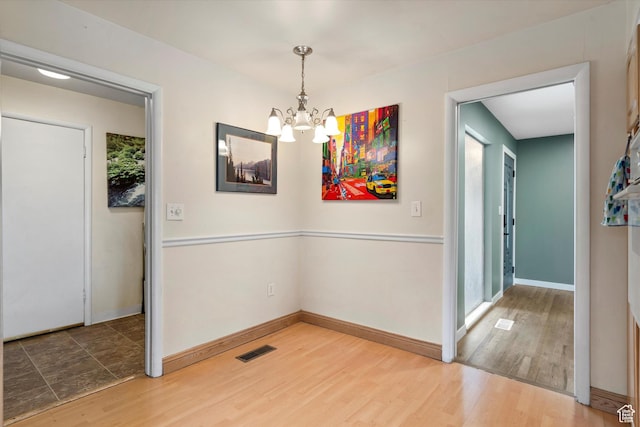 1320 Country Hills Dr, Ogden, UT 84403 - unfurnished dining area with hardwood / wood-style floors and a chandelier