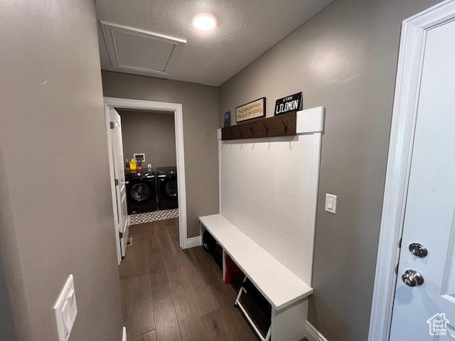 mudroom with dark wood-style flooring, washer and clothes dryer, baseboards, and a textured ceiling