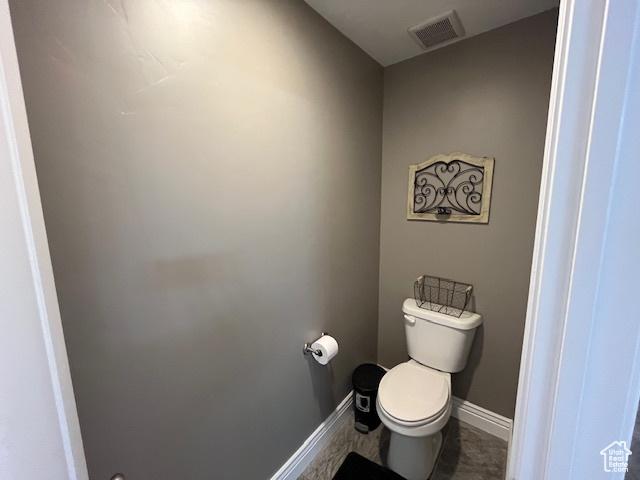 bathroom featuring toilet, baseboards, and visible vents