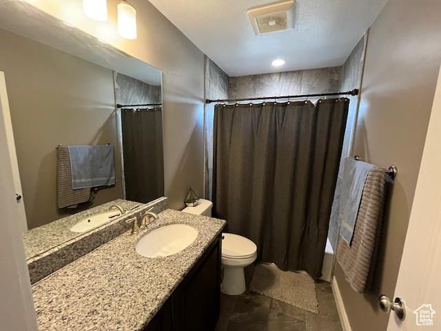 bathroom with shower / bath combo, toilet, and vanity