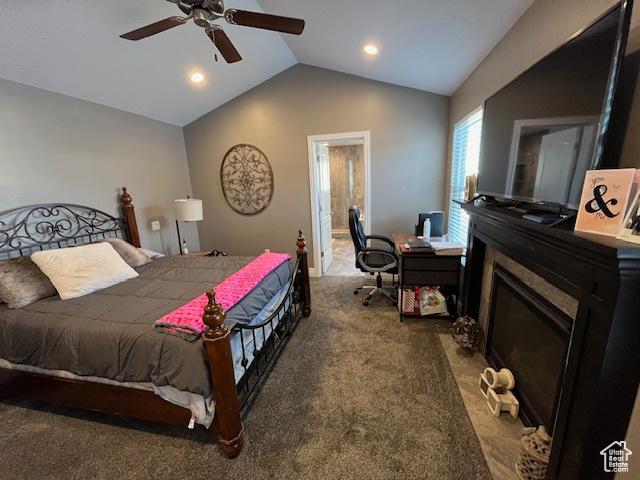 bedroom featuring a fireplace with flush hearth, ceiling fan, lofted ceiling, and carpet floors