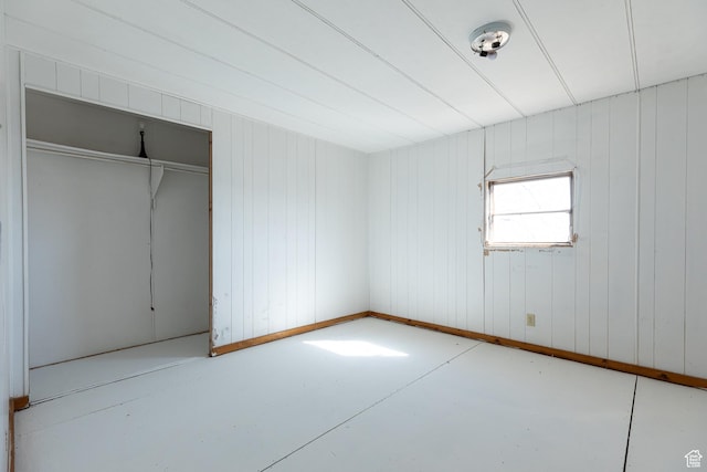 unfurnished bedroom with concrete floors and a closet
