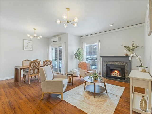 living room with an inviting chandelier, hardwood / wood-style floors, and a wall unit AC