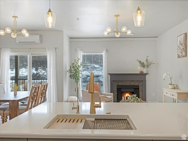 dining space with a tiled fireplace, sink, a chandelier, and a wall unit AC