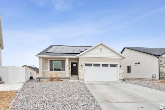 view of front of property with a garage, solar panels, and covered porch