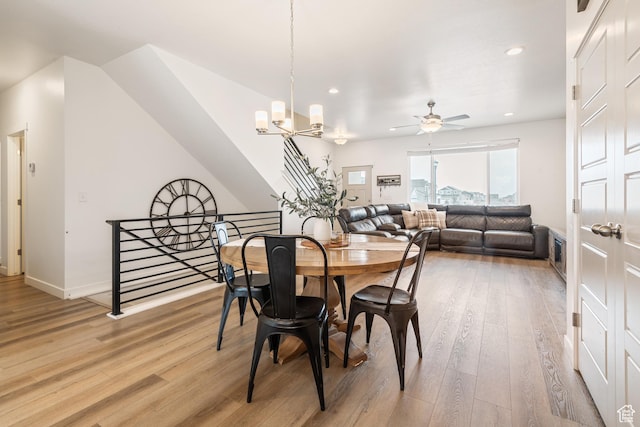 dining space with hardwood / wood-style flooring and ceiling fan with notable chandelier