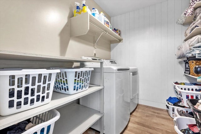 clothes washing area featuring separate washer and dryer and light hardwood / wood-style floors