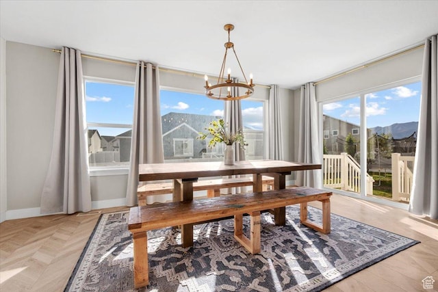 dining area with a mountain view, light parquet floors, and a notable chandelier
