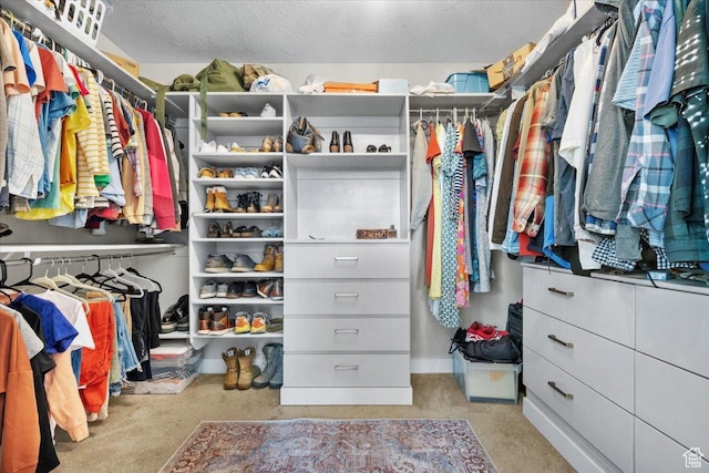 walk in closet with light carpet