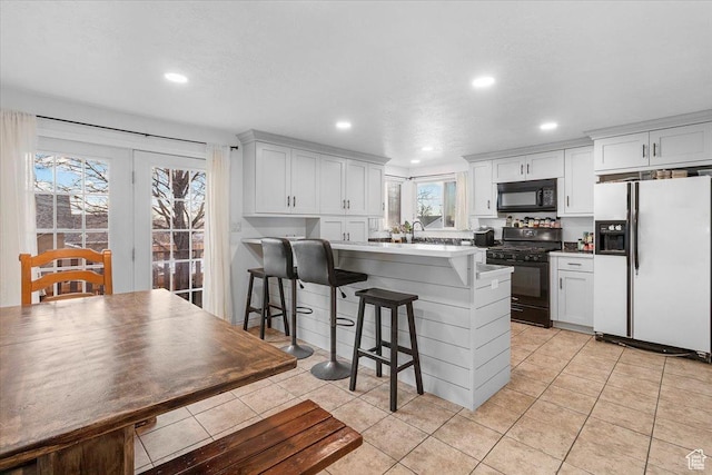 180 W 300 S, Fillmore, UT 84631 - kitchen with white cabinetry, a kitchen bar, and black appliances