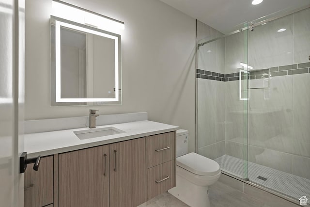 bathroom featuring vanity, a shower stall, and toilet