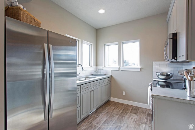 kitchen with gray cabinets, tasteful backsplash, appliances with stainless steel finishes, and sink