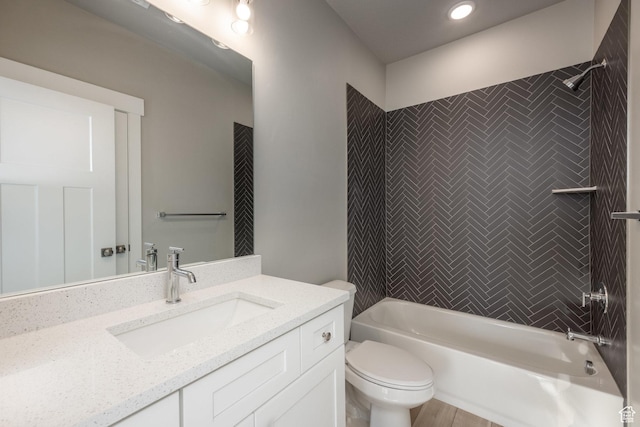 full bathroom with vanity, tiled shower / bath combo, and toilet