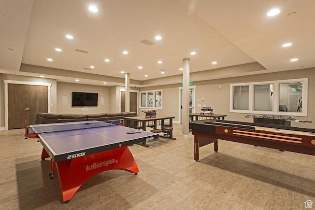 recreation room featuring a raised ceiling